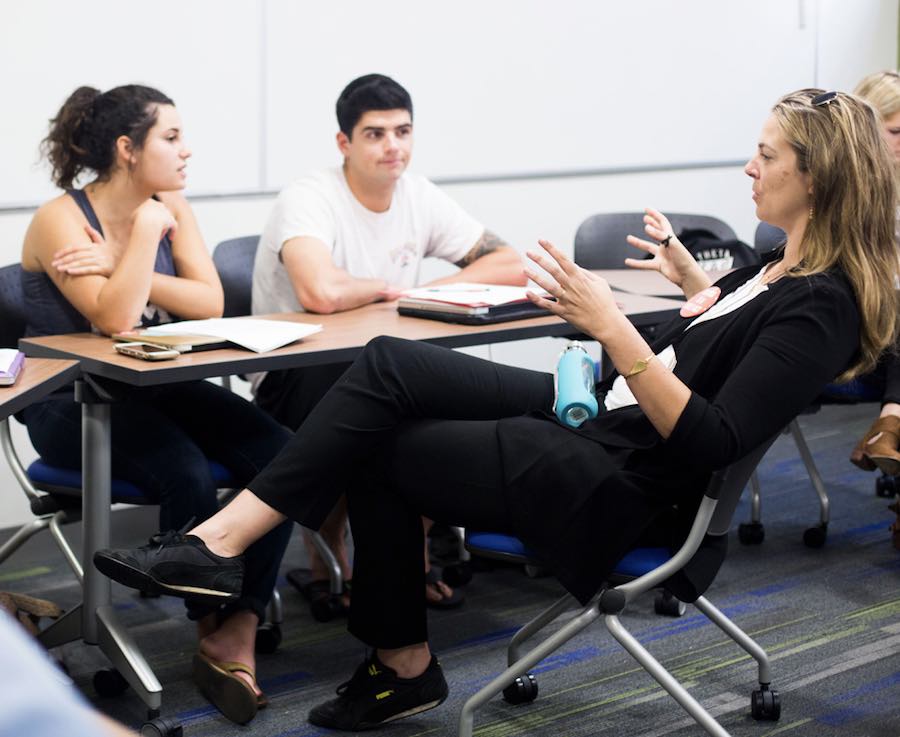 professor working with two students in classroom